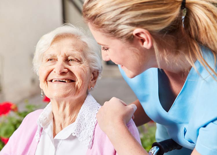 Young nurse smiling with elderly woman