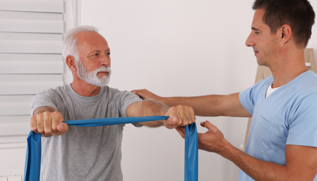 Nurse helps elderly patient with physical therapy